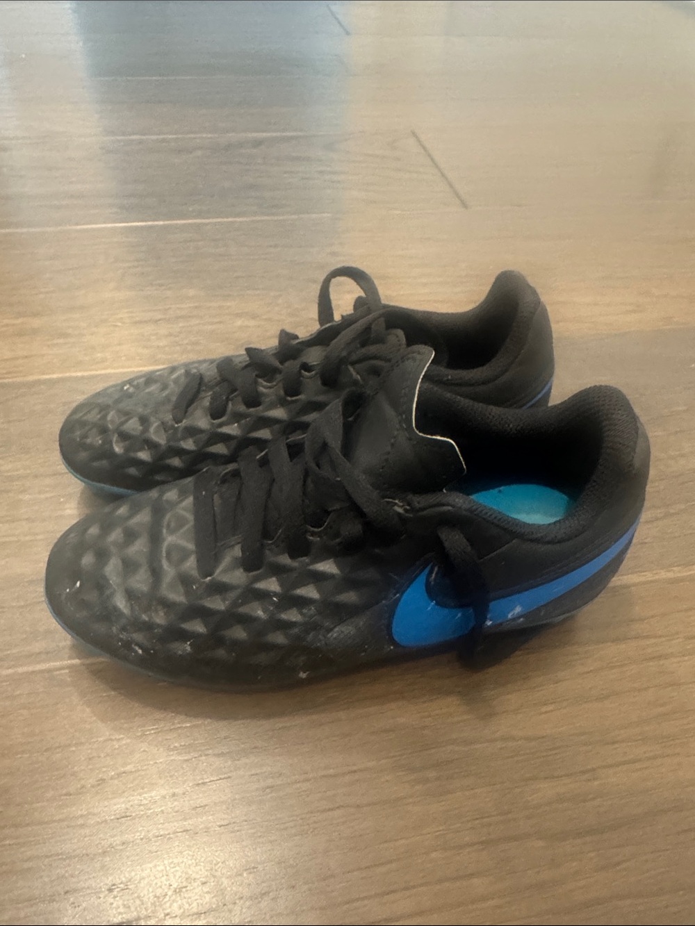 Nike Kids Black soccer cleats with Blue Swoosh